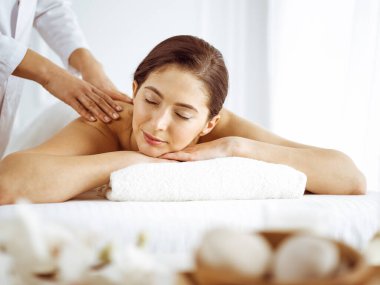 Güzel esmer kadın gözleri kapalı sırt masajından hoşlanıyor. Spa ve tıp konsepti