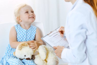 Her zamanki tıbbi muayenede gülümseyen çocuk hasta. Doktor ve hasta klinikte. Tıp, sağlık hizmetleri kavramları