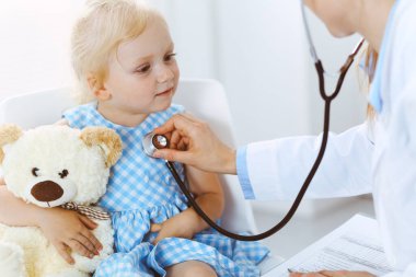 Her zamanki tıbbi muayenede gülümseyen çocuk hasta. Doktor ve hasta klinikte. Tıp, sağlık hizmetleri kavramları