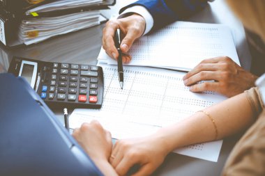 Muhasebeci ya da mali müfettiş ve sekreter rapor hazırlıyor, hesaplıyor ya da dengeyi kontrol ediyor. Milli Gelir İdaresi müfettişi mali belgeleri kontrol ediyor. Denetim kavramı.