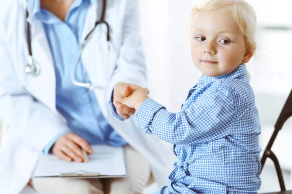 Gelukkige glimlachende kindpatiënt bij gebruikelijke medische inspectie. Dokter en patiënt in de kliniek. Geneeskunde, gezondheidsconcepten — Stockfoto
