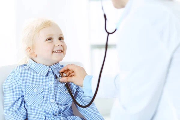 Счастливого улыбающегося ребенка при обычном медицинском осмотре. Врач и пациент в клинике. Медицина, концепции здравоохранения — стоковое фото