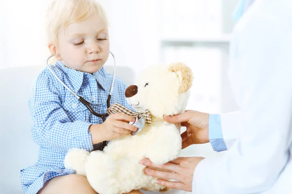 Gelukkige glimlachende kindpatiënt bij gebruikelijke medische inspectie. Dokter en patiënt in de kliniek. Geneeskunde, gezondheidsconcepten — Stockfoto