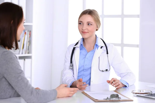 Young woman doctor and patient at medical examination at hospital office. Blue color blouse of therapist looks good. Medicine and healthcare concept — Stock Photo, Image