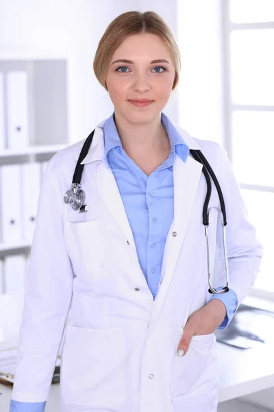 병원에서 일하는 젊은 여성 의사가 카메라를 보고 있습니다. 파란 색의 상담용 블라우스가 좋아 보이네요. 의학과 건강 관리 개념 — 스톡 사진