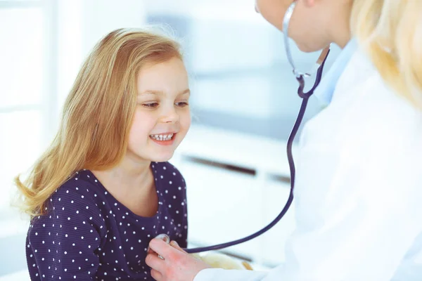 Médico examinando uma criança paciente por estetoscópio. Menina bonito na consulta médica. Conceito de medicina — Fotografia de Stock