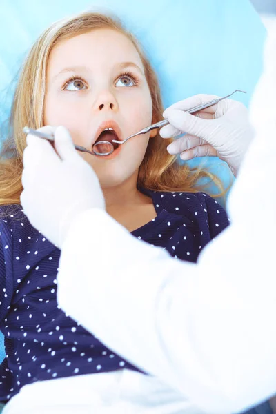 Kislány ül a fogorvosi székben nyitott szájjal orális ellenőrzés során, miközben az orvos. Fogorvosi rendelőbe megyek. Orvosi fogalom. Tonizált fénykép — Stock Fotó