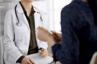 Doktor ve hasta klinikte otururken sağlık muayenesini tartışıyorlar. Hastanede mükemmel bir tıbbi hizmet. Tıp konsepti