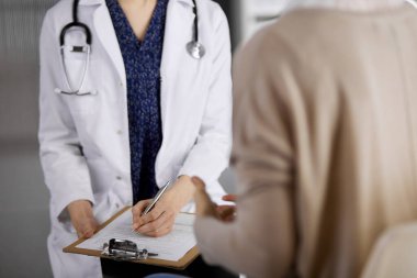 Doktor ve hasta klinikte otururken sağlık muayenesini tartışıyorlar. Hastanede mükemmel bir tıbbi hizmet. Tıp konsepti