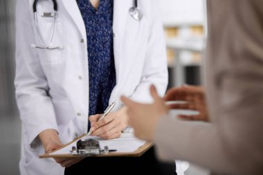 Doktor ve hasta klinikte otururken sağlık muayenesini tartışıyorlar. Hastanede mükemmel bir tıbbi hizmet. Tıp konsepti