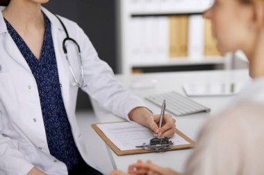 Doktor ve hasta klinikte otururken sağlık muayenesini tartışıyorlar. Hastanede mükemmel bir tıbbi hizmet. Tıp konsepti