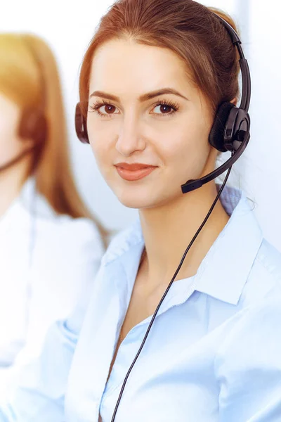 Operatori di call center. Concentrarsi sulla bella donna d'affari utilizzando cuffie in ufficio soleggiato — Foto Stock