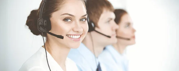 Call center. Diverse customer service operators in headsets at work in office. Business concept