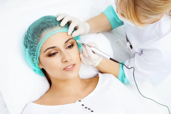 Professionele schoonheidsspecialiste die wenkbrauwtatoeage doet op vrouwengezicht. Permanente make-up in schoonheidssalon, close-up. Cosmetologische behandeling — Stockfoto