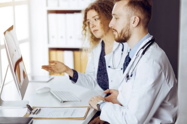 Kızıl sakallı doktor ve bayan meslektaşı güncel hastalık terapisini güneşli klinikte çalışırken tartışıyorlar. Tıpta takım çalışması