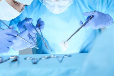 Tıbbi ekibin operasyon için yakın plan çekimleri. Bir grup cerrah hastalarıyla meşgul. Hastanede tıp, veterinerlik veya sağlık hizmetleri ve acil servis