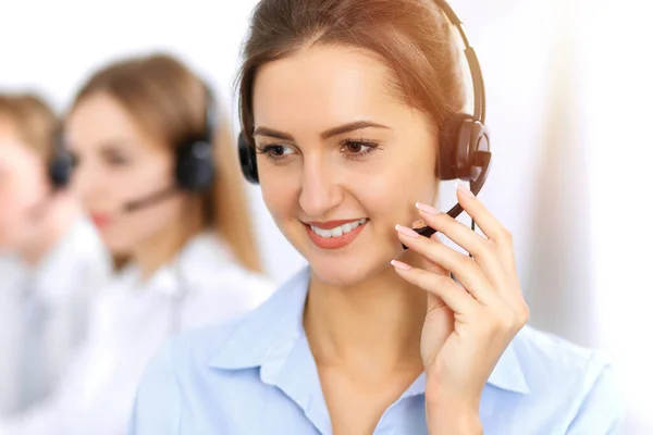 Bel het centrum. Focus op mooie zakelijke vrouw met behulp van headset in zonnig kantoor — Stockfoto