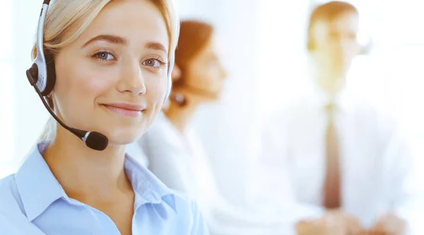 一群多样化的电话接线员在阳光灿烂的办公室里工作.漂亮的女商人带着耳机咨询客户。呼叫中心和商务人士的概念 — 图库照片