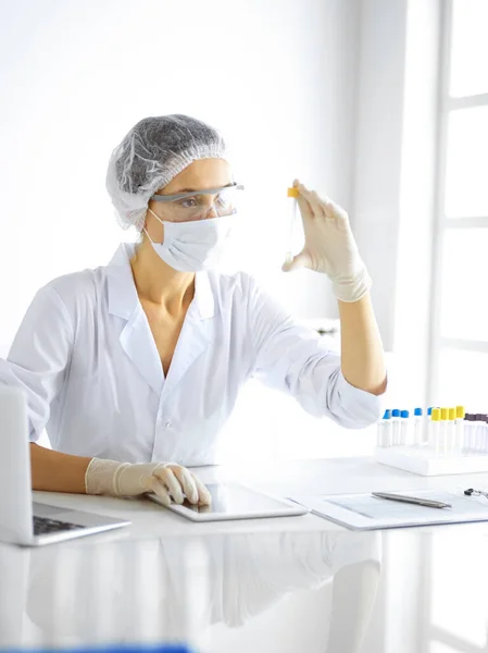 Científica profesional en gafas protectoras investigando tubo con reactivos en laboratorio. Conceptos de medicina e investigación — Foto de Stock