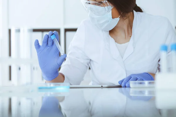 Close-up de cientista profissional feminino em óculos de proteção fazendo experiência com reagentes em laboratório. Medicina e conceito de pesquisa — Fotografia de Stock