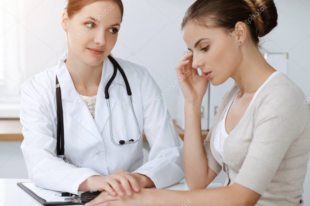 Doctor and patient sitting and discussing health examination results in sunny clinic