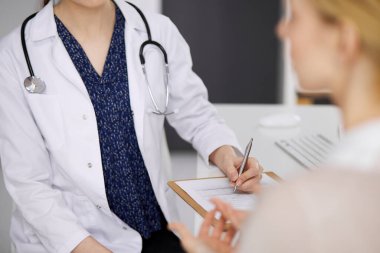 Doktor ve hasta klinikte otururken sağlık muayenesini tartışıyorlar. Hastanede mükemmel bir tıbbi hizmet. Tıp konsepti