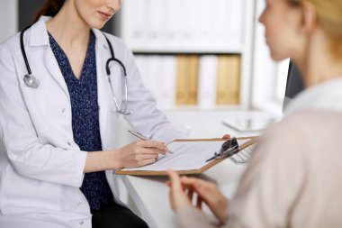 Doktor ve hasta klinikte otururken sağlık muayenesini tartışıyorlar. Hastanede mükemmel bir tıbbi hizmet. Tıp konsepti