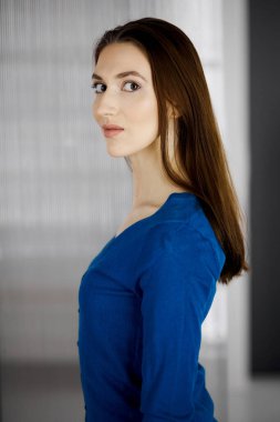 Dost canlısı Asyalı öğrenci kız dik duruyor. İş vesikalığı ya da ofiste portre