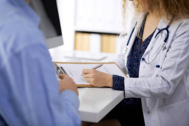 Kadın doktor ve erkek hasta klinikte otururken sağlık muayenesini tartışıyorlar. Tıp konsepti