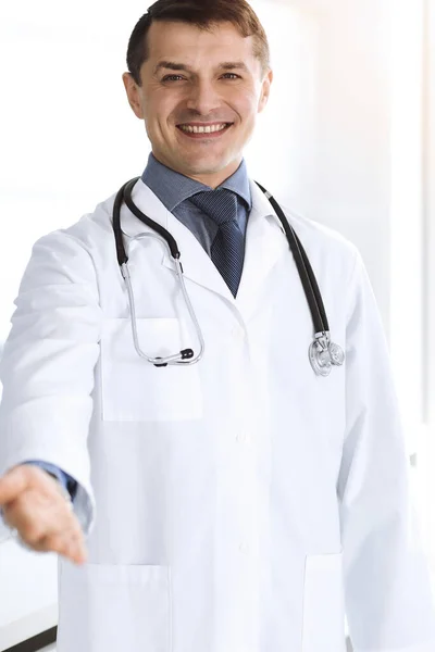 Arzt lächelt fröhlich in die Kamera und hilft. Perfekte medizinische Versorgung in der Klinik. Glückliche Zukunft in Medizin und Gesundheitswesen — Stockfoto