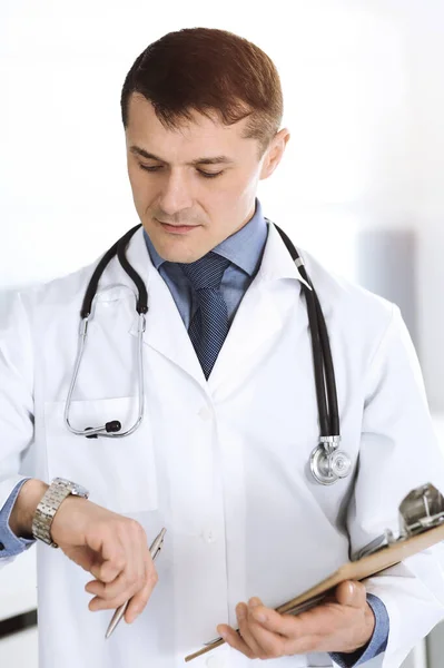 Doctor hombre usando portapapeles para llenar los registros del historial de medicamentos. Servicio médico perfecto en la clínica. Médico trabajando en el hospital. Medicina y conceptos sanitarios — Foto de Stock