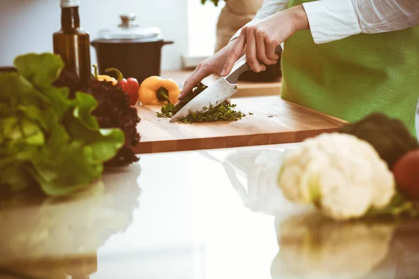 Onbekende mensenhanden die koken in de keuken. Vrouw is bezig met groentesalade. Gezonde maaltijd en vegetarisch voedselconcept — Stockfoto