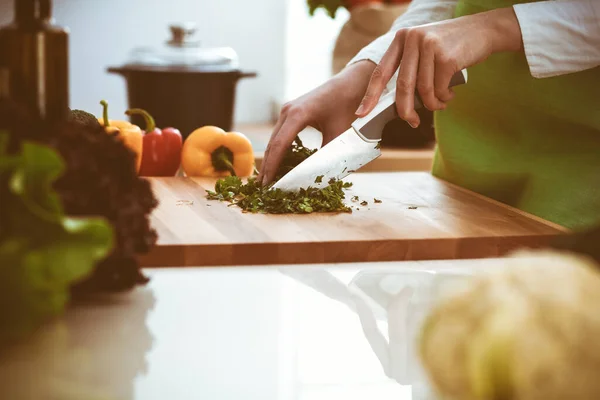 Mãos humanas desconhecidas a cozinhar na cozinha. A mulher está ocupada com salada de legumes. Refeição saudável e conceito de comida vegetariana — Fotografia de Stock