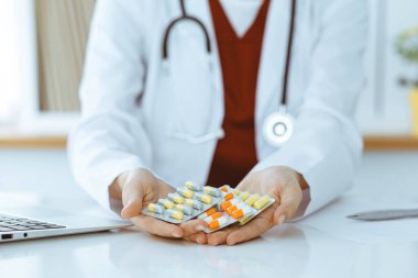 Bilinmeyen kadın doktor farklı tablet kabarcıkları sunuyor, yakın plan. Tıp konsepti