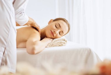 Güzel bir kadın kapalı gözlerle sırt masajından hoşlanıyor. Spa tedavisi kavramı