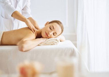Güzel bir kadın kapalı gözlerle sırt masajından hoşlanıyor. Spa tedavisi kavramı