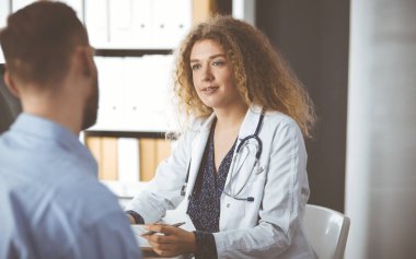 Kadın doktor ve erkek hasta klinikte otururken sağlık muayenesini tartışıyorlar. Tıp konsepti