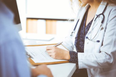 Kadın doktor ve erkek hasta klinikte otururken sağlık muayenesini tartışıyorlar. Tıp konsepti