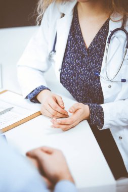 Kadın doktor ve erkek hasta klinikte otururken sağlık muayenesini tartışıyorlar. Tıp konsepti