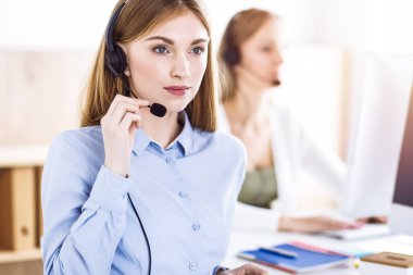 Çağrı merkezi operatörünün tonlu portresi. Kulaklık takmış bir grup insan müşterilere yardım etmeye hazır. İş konsepti