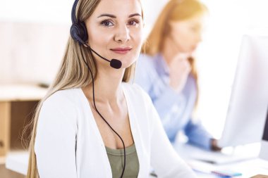 Çağrı merkezi operatörünün tonlu portresi. Kulaklık takmış bir grup insan müşterilere yardım etmeye hazır. İş konsepti