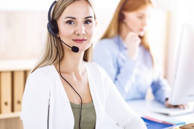 Çağrı merkezi operatörünün tonlu portresi. Kulaklık takmış bir grup insan müşterilere yardım etmeye hazır. İş konsepti