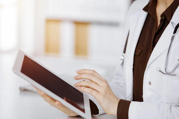 Neznámá doktorka používající tablet na slunné klinice. Perfektní lékařská služba v nemocnici — Stock fotografie