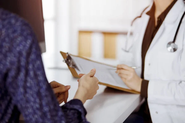 Médico e paciente discutindo o exame de saúde atual enquanto sentado na clínica ensolarada. Serviço médico perfeito no hospital — Fotografia de Stock