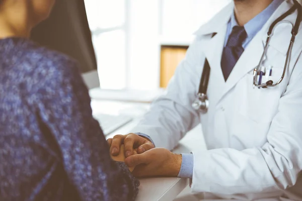 Amigável médico de barba vermelha tranquilizando sua paciente, close-up. Ética médica e conceito de confiança, tema da medicina — Fotografia de Stock