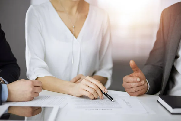 Elderly businessman and group of business people discussing contract in sunny office, close-up — Stock Photo, Image