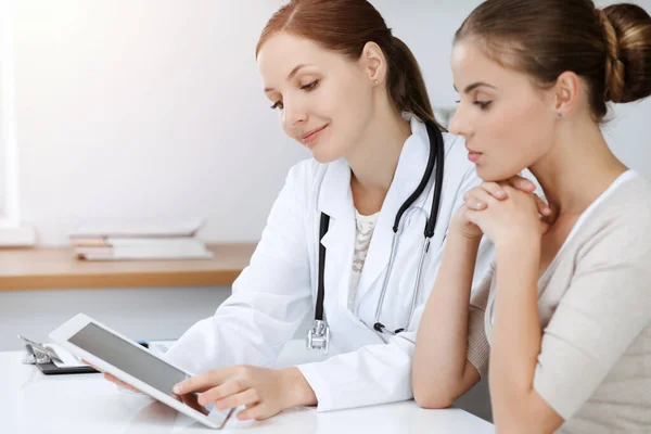 Orvos és a beteg ül, és megvitassák az egészségügyi vizsgálati eredmények használata közben tabletta számítógép — Stock Fotó
