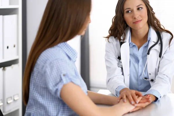 Dokter stelt haar vrouwelijke patiënt gerust. Medische ethiek en vertrouwensconcept. Thema geneeskunde en gezondheidszorg — Stockfoto