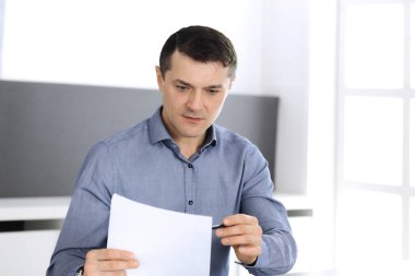 Modern ofiste tablet bilgisayarla çalışan bir iş adamı. İş yerindeki erkek girişimcinin ya da şirket müdürünün vesikalığı. İş konsepti