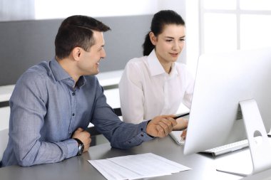Neşeli gülümseyen iş adamı ve modern ofiste bilgisayarla çalışan kadın. Toplantıda ya da iş yerinde vesikalık fotoğraf
